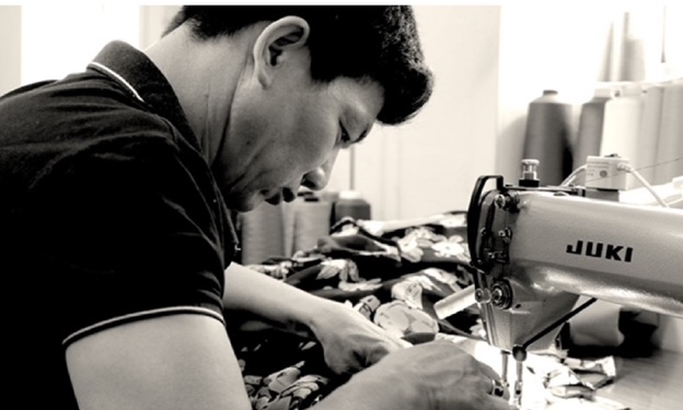 Our tailor sewing a garment at the machine in the Hoang Giang workshop